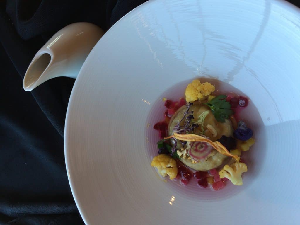Raviolo stuffed with Proffitt Family Farms certifiec organic ground beef gemovese, Sianno straccialtella cheese, Burtonfarms Sauteed beets, yellow and romesco cauliflowre, Auston farm baby carrots, pruple cauliflower consomme